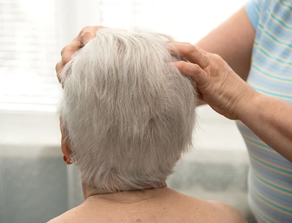 Mulher idosa fazendo massagem facial — Fotografia de Stock