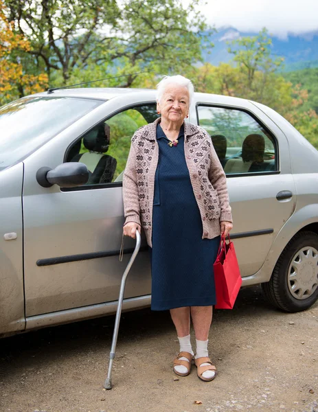 Oude vrouw met shopping tassen — Stockfoto