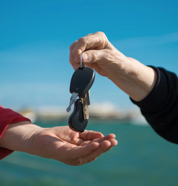 Manos y una llave del coche — Foto de Stock