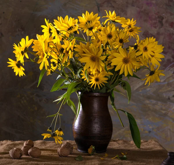 Bunch of bright yellow flowers (rudbeckia) in brown vase and wal — Stock Photo, Image