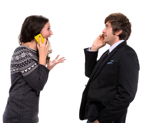 Homem e mulher surpresos com telefones celulares — Fotografia de Stock