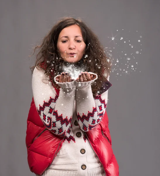 Femme attrayante soufflant la neige — Photo