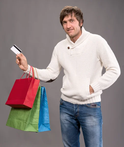 Hombre sosteniendo bolsas de compras y tarjeta de crédito —  Fotos de Stock