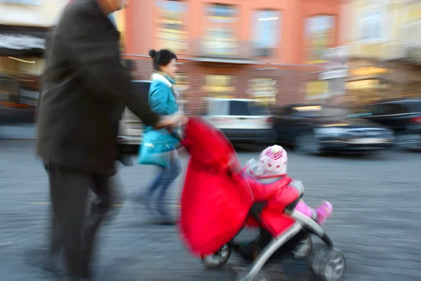Os pais caminham com a criança no carrinho — Fotografia de Stock