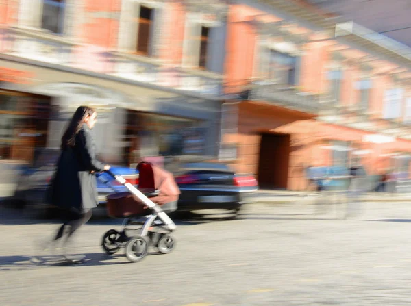 Moeder wandelingen met het kind in de wandelwagen — Stockfoto