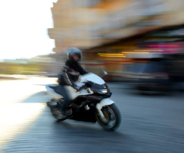 Motociclista em movimento descendo a rua — Fotografia de Stock