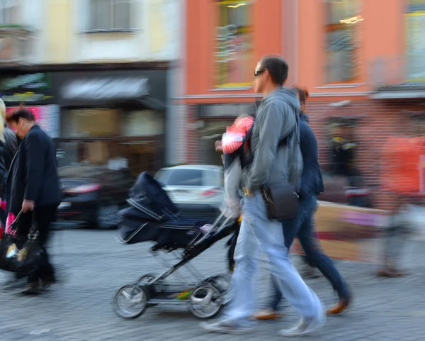 Os pais caminham com a criança no carrinho — Fotografia de Stock