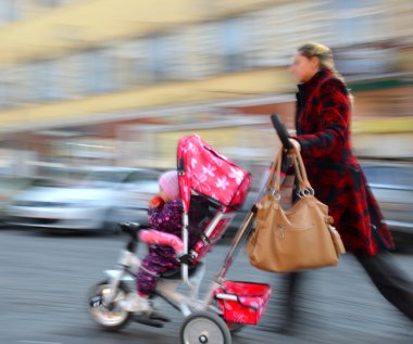 Bebek arabası çocuk ile anne yürür