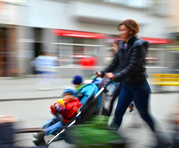 Äiti kävelee lapsen kanssa rattaissa — kuvapankkivalokuva