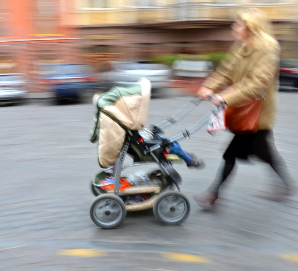 Mamma går med barnet i vagnen — Stockfoto