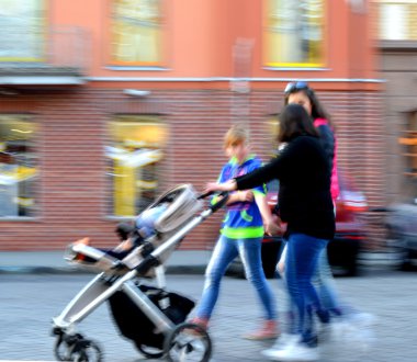 bebek arabası olan bir çocuk ile yürüyen kadınlar