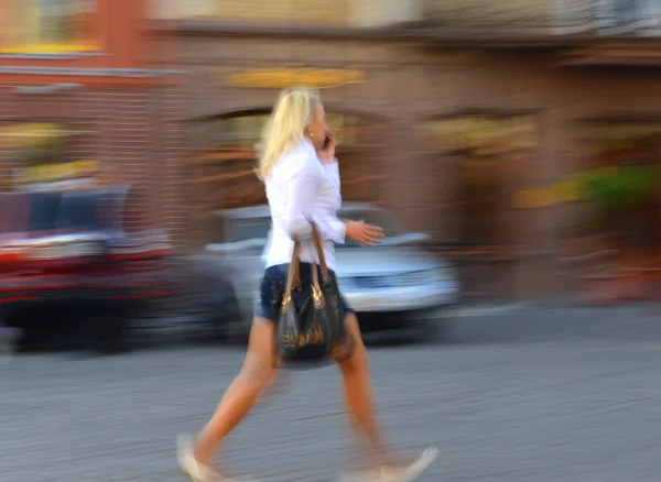 Woman talking on a cell phone in a hurry — Stock Photo, Image