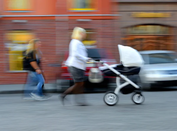Mutter geht mit Kind im Kinderwagen — Stockfoto