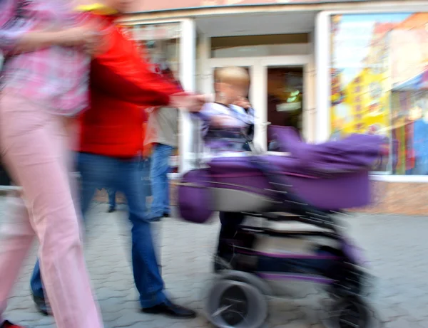 Chodí rodiče s dítětem v kočárku — Stock fotografie