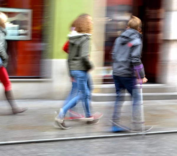 Женщины и мальчик на костылях ходят по городской улице — стоковое фото