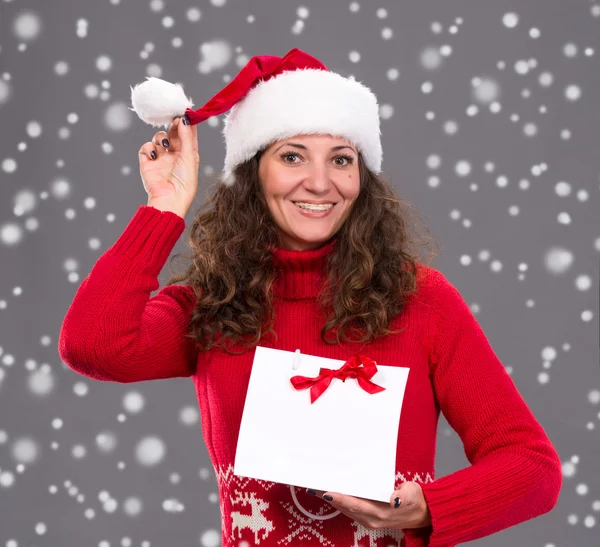 Noel Baba şapkası ile alışveriş çantası içinde gülümseyen kadın — Stok fotoğraf