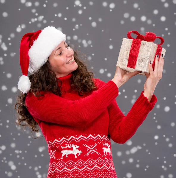 Donna sorridente in cappello di Babbo Natale con confezione regalo — Foto Stock