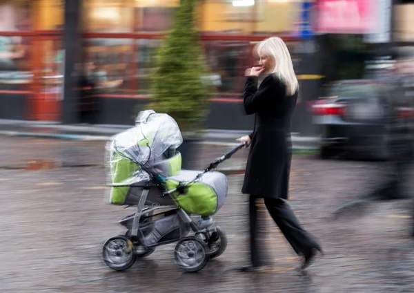 Matka chodí s dítětem v kočárku — Stock fotografie