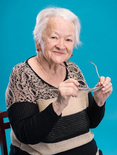 Yaşlı kadın holding gözlük — Stok fotoğraf