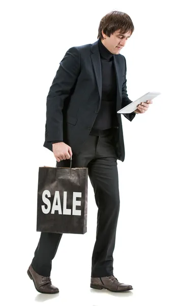 Bonito homem com tablet pc e saco de compras — Fotografia de Stock