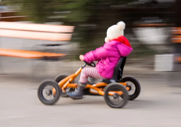 Mädchen rast in Pedalkarre — Stockfoto