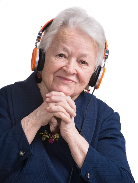 Oude vrouw luisteren naar muziek in hoofdtelefoon — Stockfoto