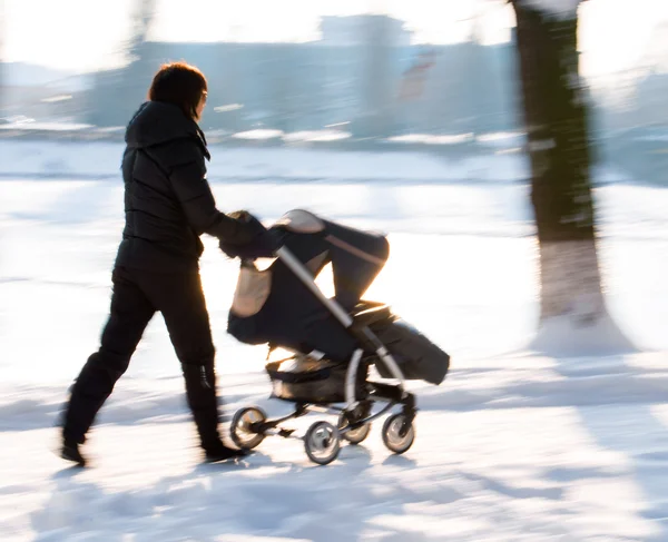 Bebek arabası çocuk ile anne yürür — Stok fotoğraf
