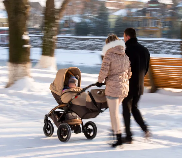 Ouders lopen met het kind in de wandelwagen — Stockfoto