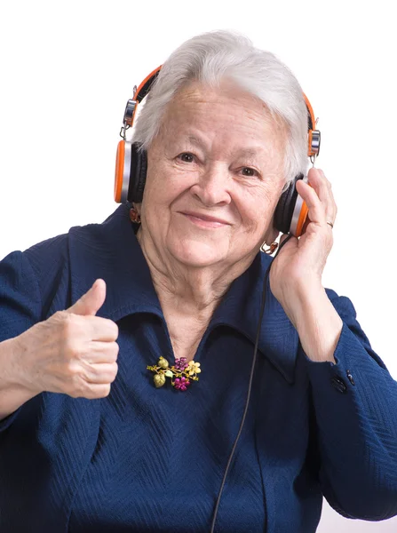 Mulher velha ouvindo música em fones de ouvido — Fotografia de Stock