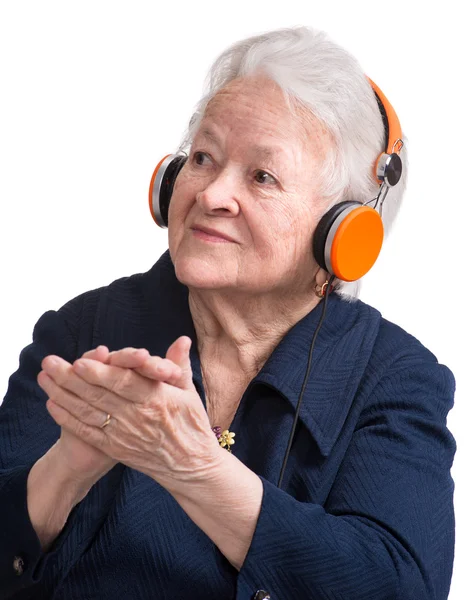 Mulher velha ouvindo música em fones de ouvido — Fotografia de Stock