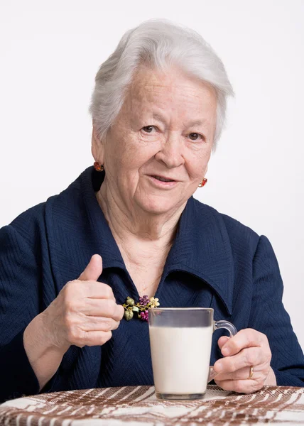 Alte Frau mit Glas Milch — Stockfoto