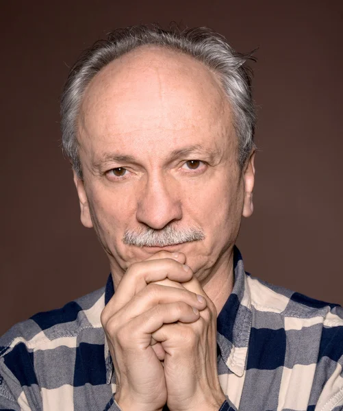 Elderly man on a brown background — Stock Photo, Image