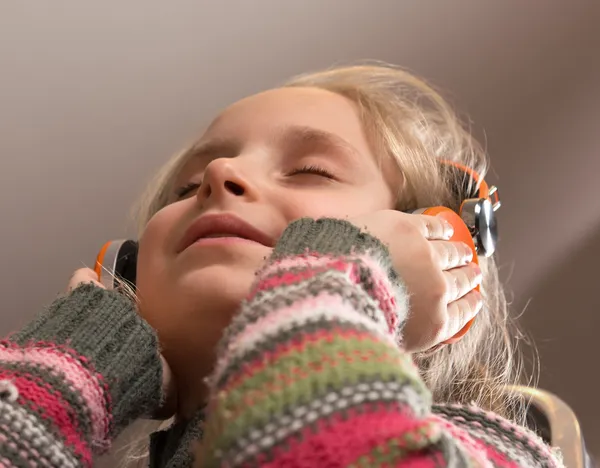 हेडफोन्समध्ये लहान मुलगी संगीत ऐकणे — स्टॉक फोटो, इमेज