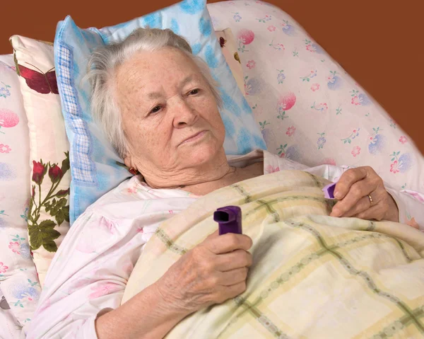 Sick old woman lying at bed — Stock Photo, Image