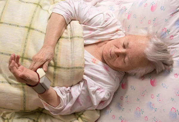 Old woman measures arterial pressure — Stock Photo, Image