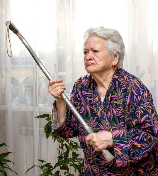 Velha mulher zangada ameaçando com uma bengala — Fotografia de Stock