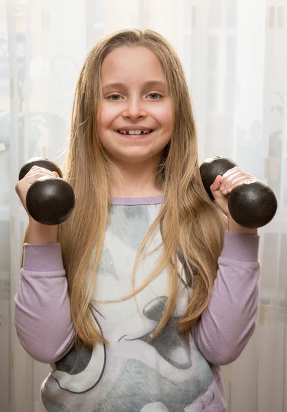 Portrait of happy little girl with dumbbells — Stock Photo, Image