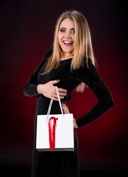 ショッピング バッグと黒のドレスの若い女性 — ストック写真