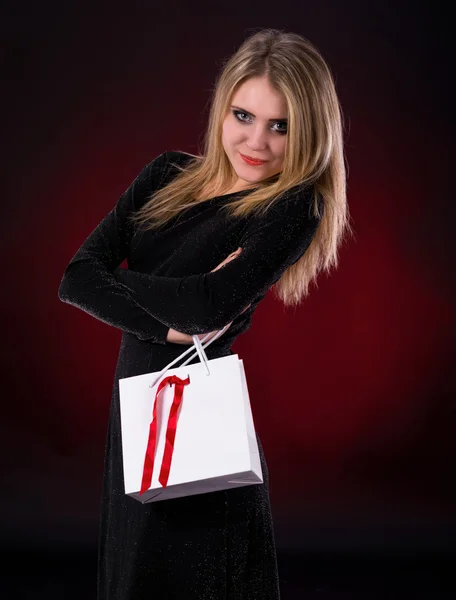 Young woman in black dress with shopping bag Royalty Free Stock Images