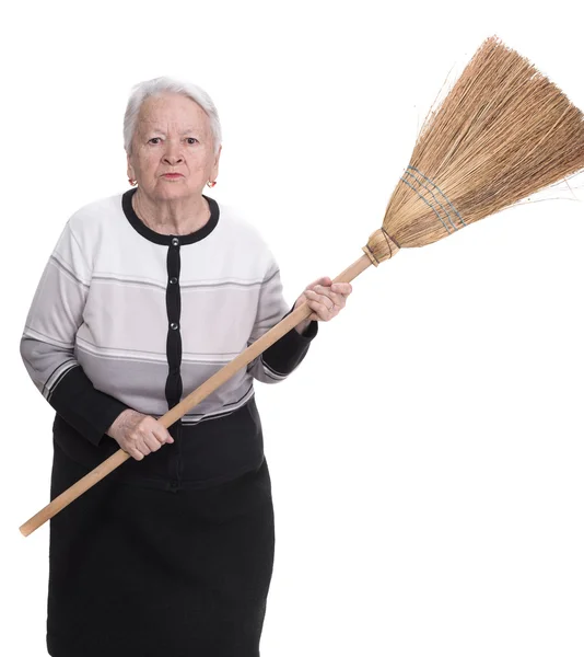 Old angry woman threatening with a broom — Stock Photo, Image