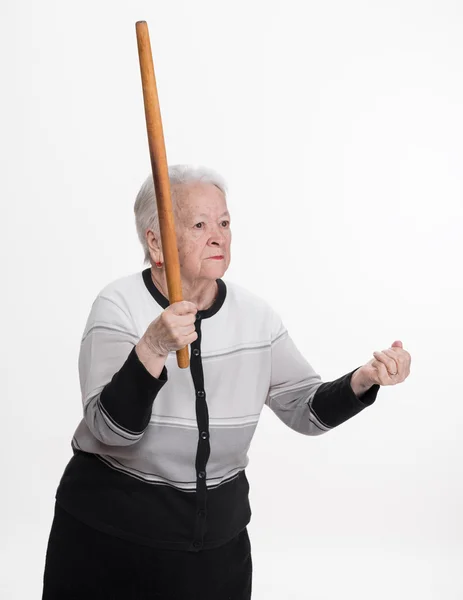 Velha mulher zangada ameaçando com um rolo — Fotografia de Stock