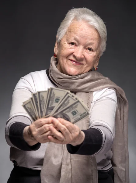 Vieja sosteniendo el dinero en las manos — Foto de Stock