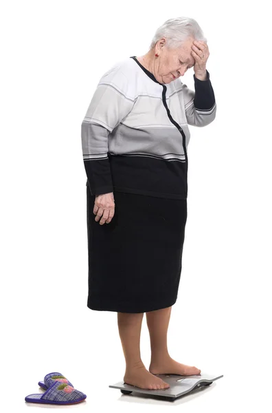 Stará žena stojící na koupelnu váhy — Stock fotografie