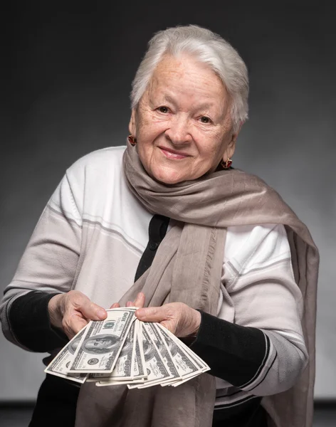Stará žena drží peníze v rukou — Stock fotografie