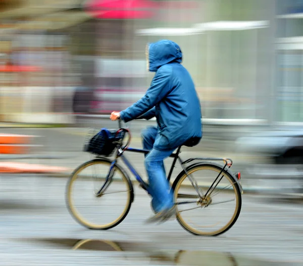 Cyclist on the city roadway in rainy day — Stock Photo, Image