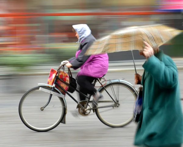 雨の日に市の道路上のサイクリスト — ストック写真