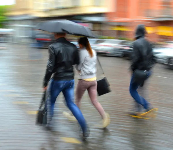 雨の日で、通りを歩いて人々 のグループ — ストック写真