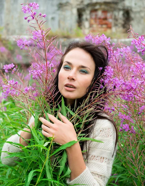 Молодая женщина позирует среди цветов — стоковое фото