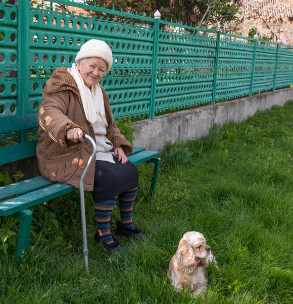 Starší žena sedí na lavičce — Stock fotografie