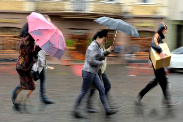 雨の日で、通りを歩いて人々 のグループ — ストック写真